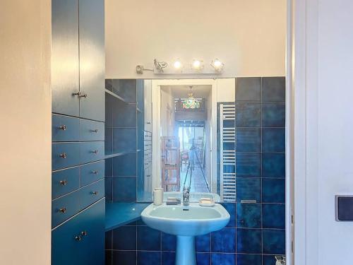 une salle de bain bleue avec un lavabo et un miroir dans l'établissement Appartement T3 avec jardin, accès direct plage - FR-1-770-43, à Saint-Cyr-sur-Mer