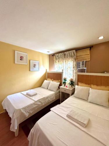 a hotel room with two beds and a window at VIP 4-Bedroom House in Butuan