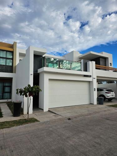 a large white house with a garage at A2P Preciosa casa con habitación abajo en Acacia Residencial in Culiacán