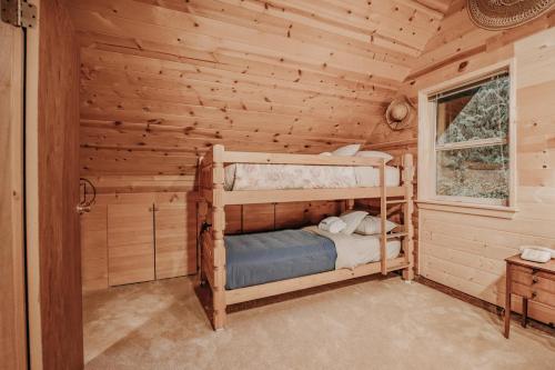 a bedroom with a bunk bed in a log cabin at Snowline Cabin 11- Log Cabin - Wi-Fi in Glacier