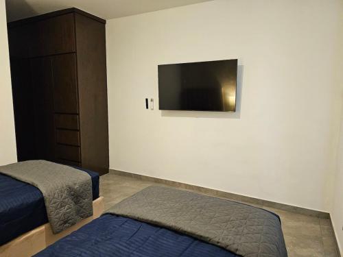 a bedroom with two beds and a flat screen tv at A2P Preciosa casa con habitación abajo en Acacia Residencial in Culiacán