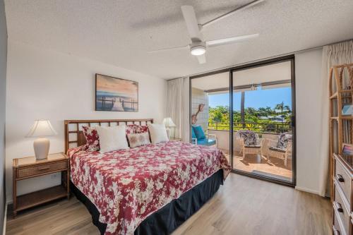 a bedroom with a bed and a view of a balcony at AC Ocean View 2b 2b condo across Magic Sands beach in Kailua-Kona
