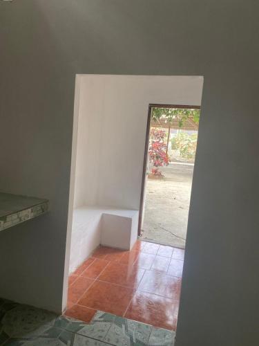 a room with a door leading into a room with a bench at Hostería del Puerto in Puerto López
