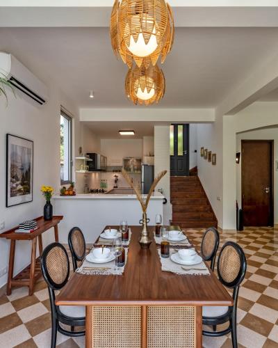 a dining room with a wooden table and chairs at La Verona - 2,3,4 BHK Villas in Assagao with Private Pool, Garden, Caretaker, Kitchen & Security in Assagao