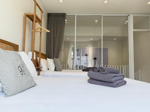 Un dormitorio con dos camas con toallas encima. en Glyn Chiangmai, Cozy Two-Story Rooms in the Heart of Chiang Mai, en Chiang Mai