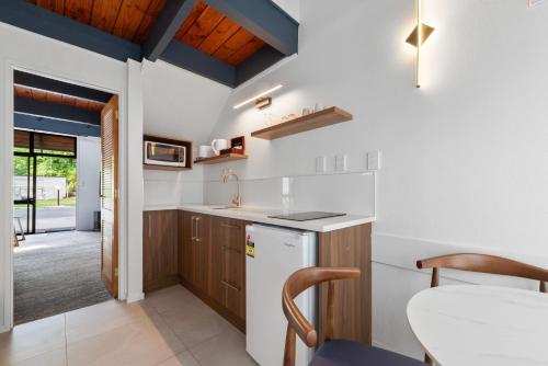a kitchen with a white refrigerator and a table at Wylie Court Motor Lodge in Rotorua