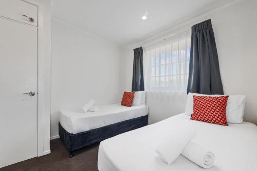 a bedroom with two beds and a window at Wylie Court Motor Lodge in Rotorua