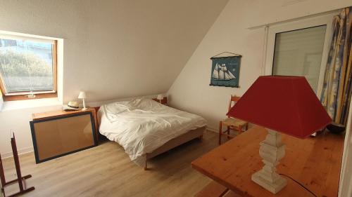 - une chambre avec un lit et une table avec une lampe rouge dans l'établissement Duplex apartment with sea view, à Carnac