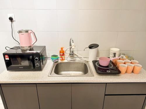 a kitchen counter with a sink and a microwave at New 2BR or 3BR Da Men Residence 7 Min to Sunway Near BRT in Subang Jaya