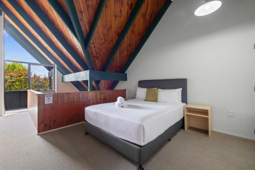 a bedroom with a large bed and a large window at Wylie Court Motor Lodge in Rotorua
