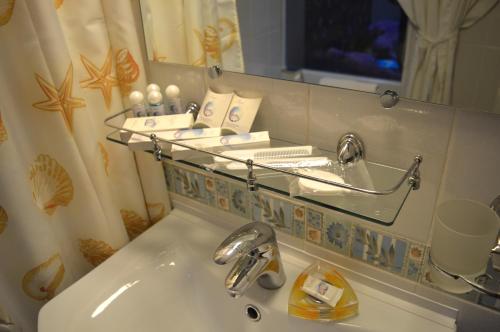 アルチョムにあるモーテル ネグスのバスルーム(鏡付きの洗面台、上に棚付)