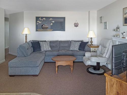 een woonkamer met een blauwe bank en een stoel bij Sea Breeze W007 Wonderful Beachfront Oceanfront property for the whole family 1897 in Wells