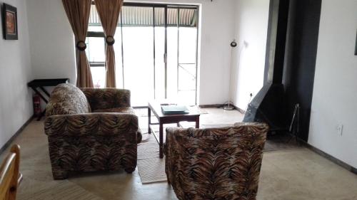 a living room with two chairs and a table at Pumula Guest Farm in Fouriesburg