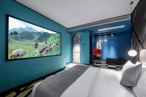 重慶市にあるReVia Skyline River View Hotel Chonggingの青い壁に大型テレビが備わるベッドルーム1室