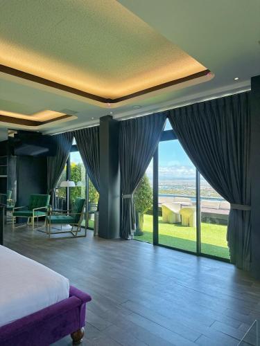 a bedroom with a bed and large windows at Azumi Boutique Hotel in Manila