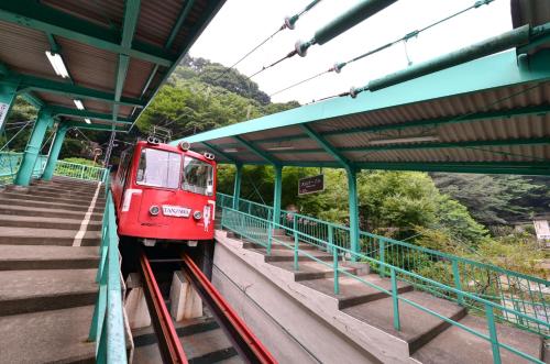 a red train is pulling into a train station at Togakubo in Isehara