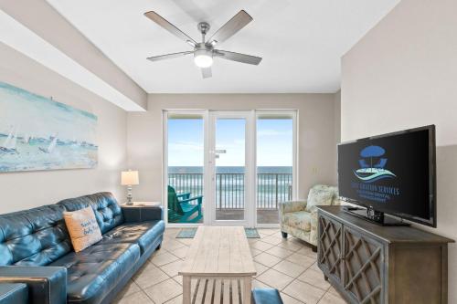 a living room with a couch and a flat screen tv at Sea Dunes 502 Beach Oasis Beachfront Condo with Pool Hot Tub Free Beach Service 0488 in Fort Walton Beach