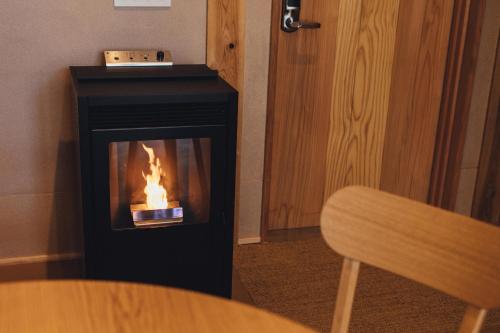 a fireplace with a fire in it in a room at SANU 2nd Home 軽井沢1st in Oiwake