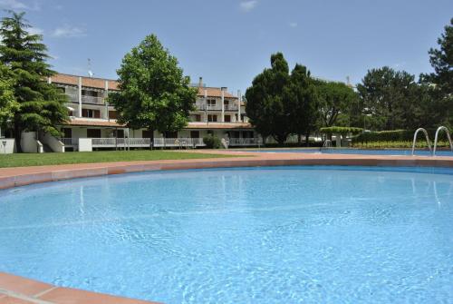 une grande piscine en face d'un bâtiment dans l'établissement Residence Selenis, à Caorle
