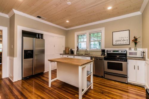 a kitchen with stainless steel appliances and a wooden floor at The Osceola Historic District Charm - 10 Minute Walk to FSC & Downtown Lakeland in Lakeland