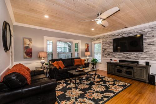 a living room with a couch and a flat screen tv at The Osceola Historic District Charm - 10 Minute Walk to FSC & Downtown Lakeland in Lakeland