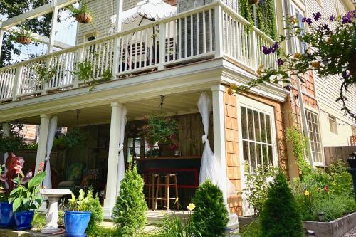 a porch with a balcony on top of a house at Palazzo Hudson - Luxury Pool, Hot Tub, and Sauna in Hudson