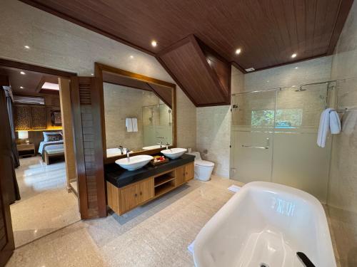 a bathroom with two sinks and a bath tub at Sakti Garden Resort & Spa in Ubud