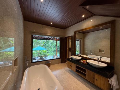 ウブドにあるSakti Garden Resort & Spaのバスルーム(シンク2台、バスタブ、大きな鏡付)
