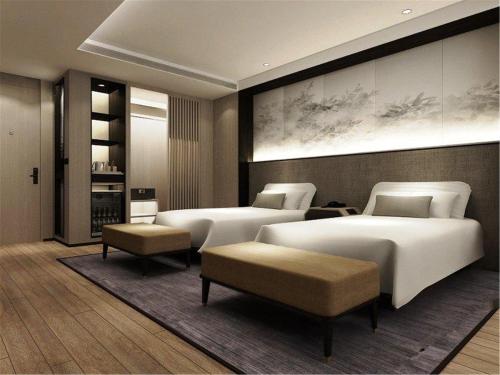 a bedroom with three beds at Mercure Dalian City Center in Dalian