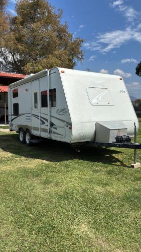 a white trailer is parked in a field at Casa Rodante Roca Azul in Jocotepec