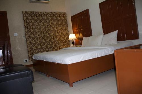 a bedroom with a large bed with white sheets at Margalla View Motel in Islamabad