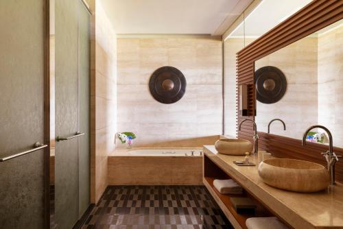 a bathroom with two sinks and a tub at Raffles Hainan Clear Water Bay in Sanya