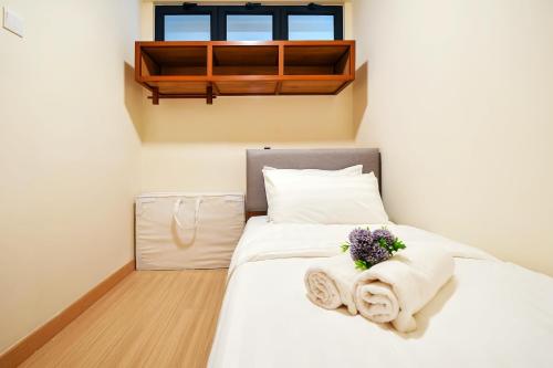 a bedroom with a bed with towels on it at TimurBay Seafront Residence Kuantan in Kuantan