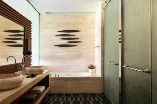 a bathroom with a tub and a sink at Raffles Hainan Clear Water Bay in Sanya