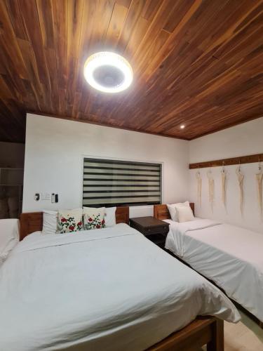 a bedroom with two beds and a ceiling with a light at Myhoa Lagoon - Kiting Town in Phan Rang