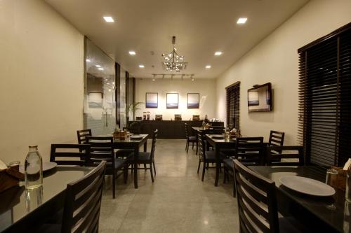 a restaurant with tables and chairs and a chandelier at Saltstayz Select - Nehru Place & New Friends Colony in New Delhi
