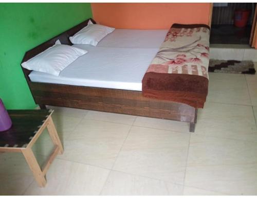 a bed in a room with a green wall at Hotel Kamla Palace, Pipalkoti in Pīpalkoti