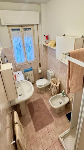 un bagno con un lavandino, un water e un lavandino di Appartamento Grazioso a Viareggio
