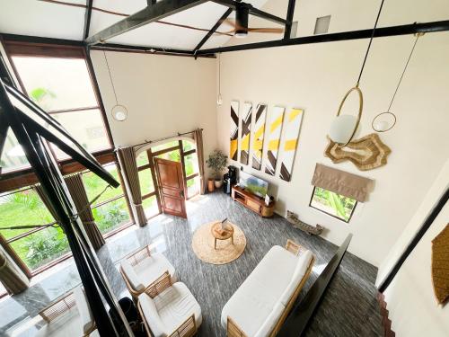 an overhead view of a living room with chairs and a table at The Phalosaa Villa in Ngaglik