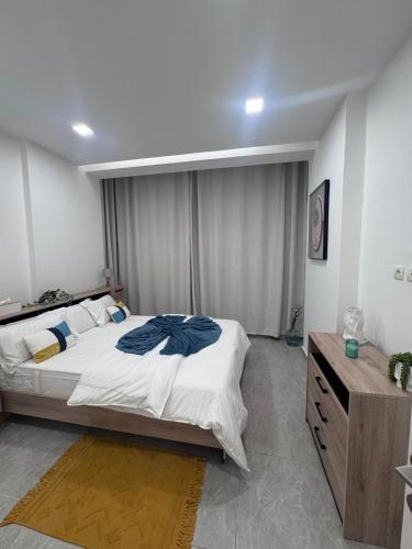 a bedroom with a large bed and a wooden dresser at Appartement 2 chambres in Libreville