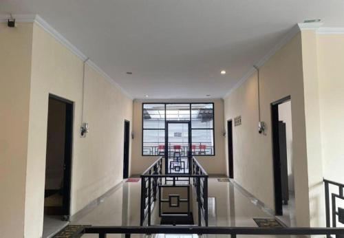 a hallway with a staircase in a building with a window at Greenhouse Exclusive Tegalwaras in Beran-kidul