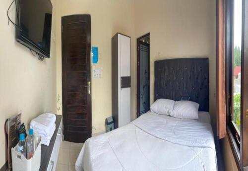 a bedroom with a bed and a flat screen tv at Greenhouse Exclusive Tegalwaras in Beran-kidul