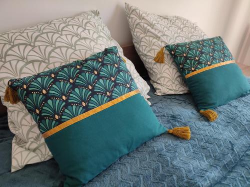 a bed with two pillows on top of it at studio cosy la Dacquoise centre-ville internet haut-débit in Dax
