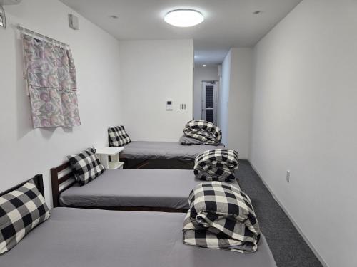 a room with two beds and two chairs in it at 旅館やすらぎ in Takamatsu