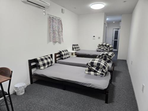 a room with two beds with pillows on them at 旅館やすらぎ in Takamatsu
