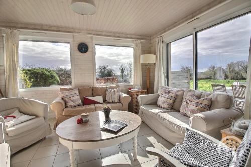 a living room with couches and a table and chairs at Glas ha gwenn in Plougrescant