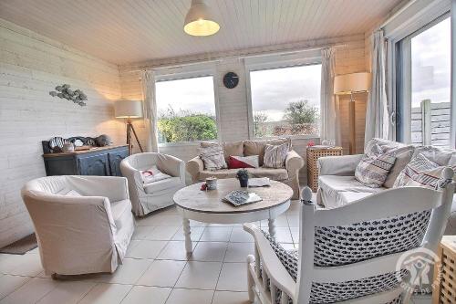 a living room with couches and a table and chairs at Glas ha gwenn in Plougrescant