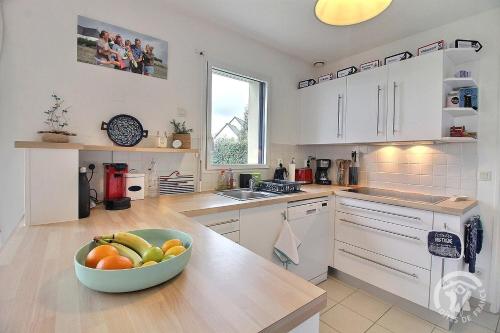 a kitchen with a bowl of fruit on a counter at Glas ha gwenn in Plougrescant