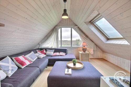 a living room with a couch and a table at Glas ha gwenn in Plougrescant