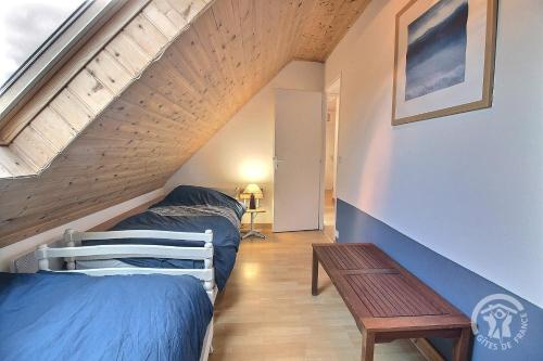 a attic bedroom with two beds and a table at Glas ha gwenn in Plougrescant